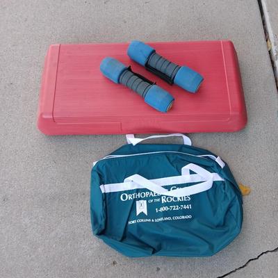 The step exercise with two hand weights and a duffle bag