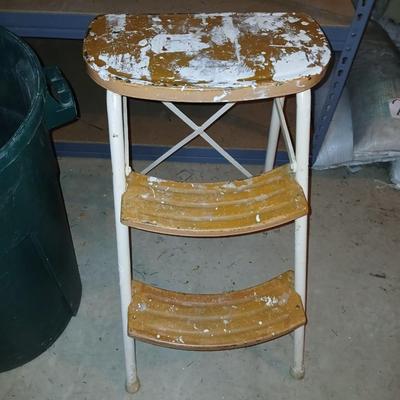 Footstool and a green trashcan with lid