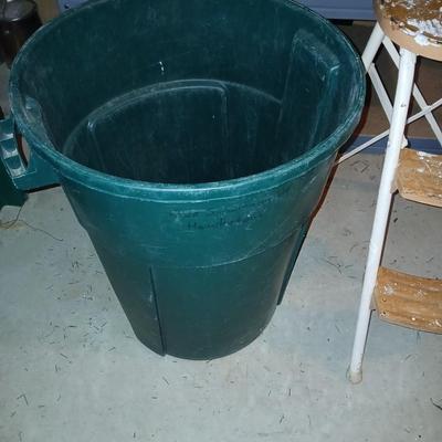 Footstool and a green trashcan with lid