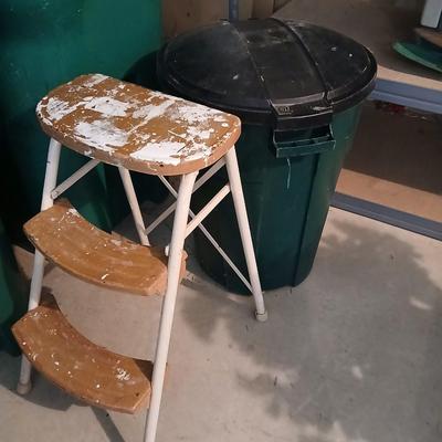 Footstool and a green trashcan with lid