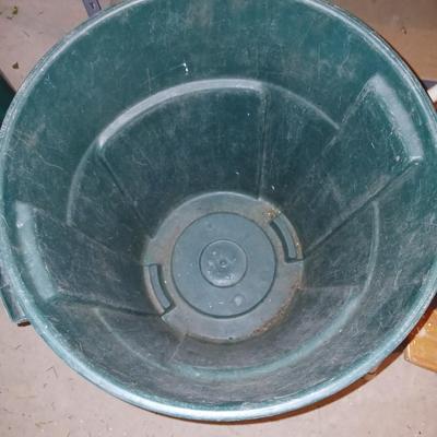 Footstool and a green trashcan with lid