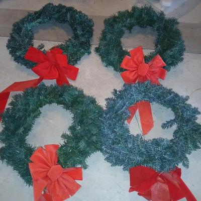 Four Christmas wreaths with red bows