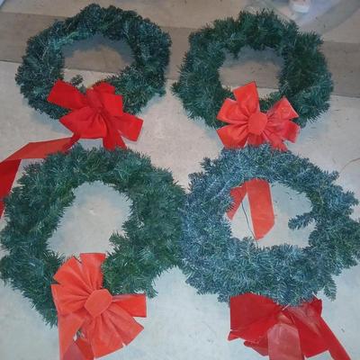 Four Christmas wreaths with red bows
