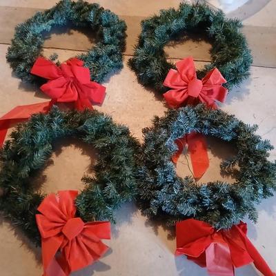 Four Christmas wreaths with red bows