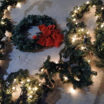 Pre-lit pine garland and a wreath with a red bow