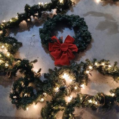 Pre-lit pine garland and a wreath with a red bow
