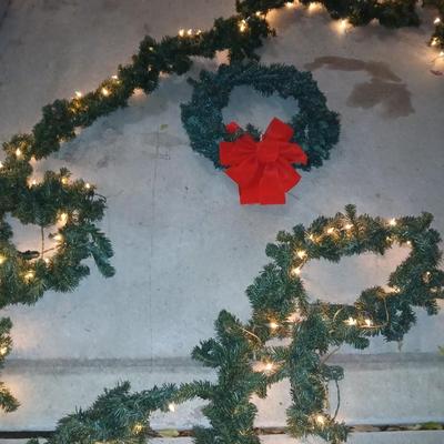 Pre-lit pine garland and a wreath with a red bow