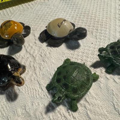 Sale Photo Thumbnail #1006: 1 ceramic turtle toothpick holder perhaps, 1 metal nut turtle, 1 plastic pencil sharpener turtle.  1 tiger's eye turtle, 1 mini crystal turtle, 2 small plastic turtles, 2 Ecuador stone turtles (one with small chip), and 1 small pottery type turtle.