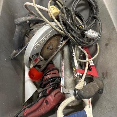 Tote of a Skilsaw, power corded drill, hand saws and cords