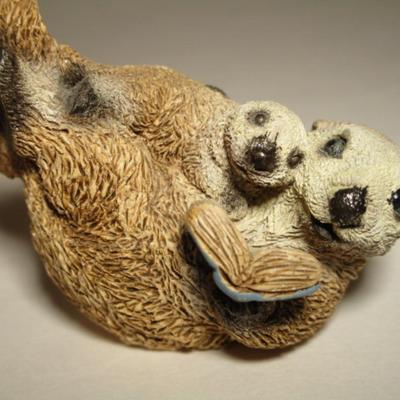 Sea otter reading a book to its child figurine