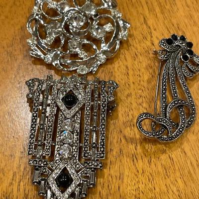 Black and silver brooches
