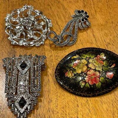 Black and silver brooches