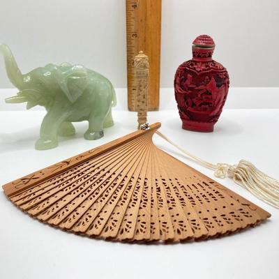 LOT 58: Vintage Asian Carved Collection - Cinnabar snuff bottle, Jade Elephant, Hand Held Filigree Wood Fan and More