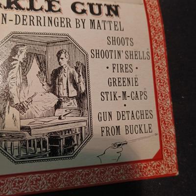 UNOPENED BUCKLE GUN REMINGTON-DERRINGER BY MATTEL ON A BOARD