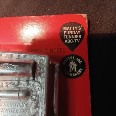 UNOPENED BUCKLE GUN REMINGTON-DERRINGER BY MATTEL ON A BOARD