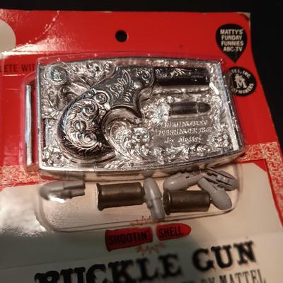 UNOPENED BUCKLE GUN REMINGTON-DERRINGER BY MATTEL ON A BOARD