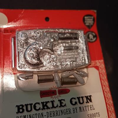 UNOPENED BUCKLE GUN REMINGTON-DERRINGER BY MATTEL ON A BOARD