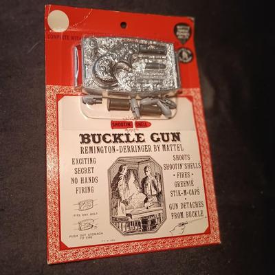 UNOPENED BUCKLE GUN REMINGTON-DERRINGER BY MATTEL ON A BOARD