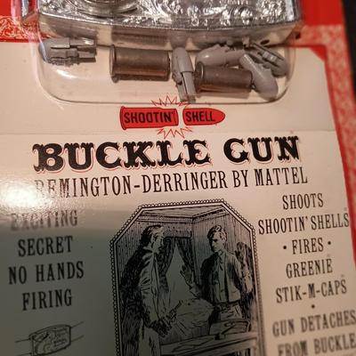 UNOPENED BUCKLE GUN REMINGTON-DERRINGER BY MATTEL ON A BOARD