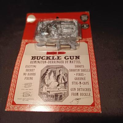 UNOPENED BUCKLE GUN REMINGTON-DERRINGER BY MATTEL ON A BOARD