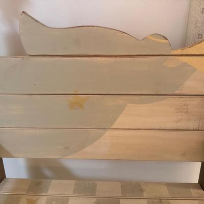 Painted wooden bench with wooden cross and wall decor