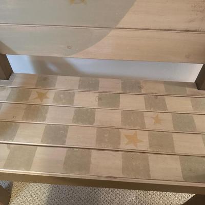 Painted wooden bench with wooden cross and wall decor