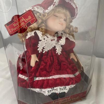 Animated, windup musical doll & 17” porcelain doll