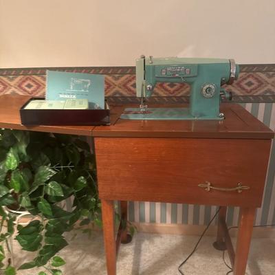 White sewing machine with wooden stand and accessories