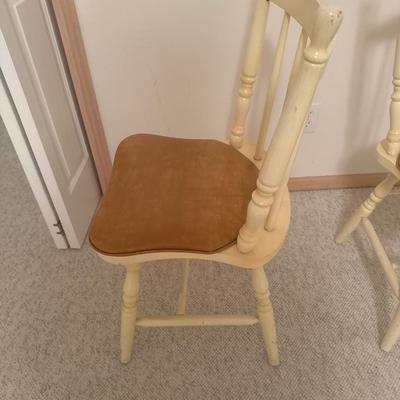 2 cream colored wooden chairs