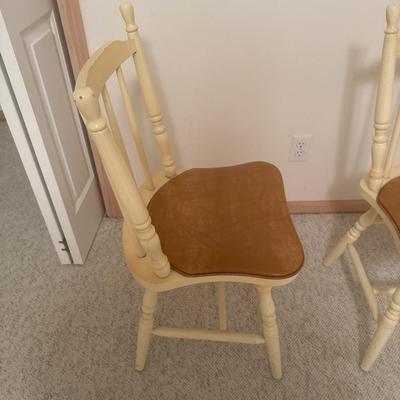 2 cream colored wooden chairs