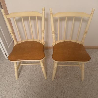 2 cream colored wooden chairs