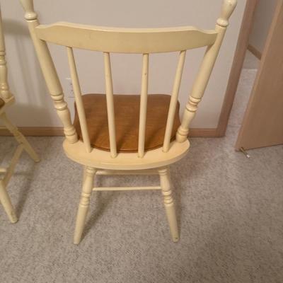 2 cream colored wooden chairs