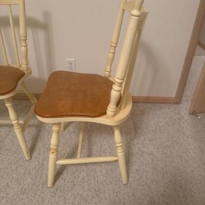 2 cream colored wooden chairs