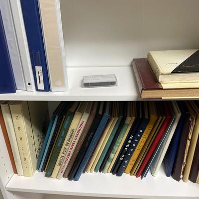 White bookshelf with binders and vintage yearbooks