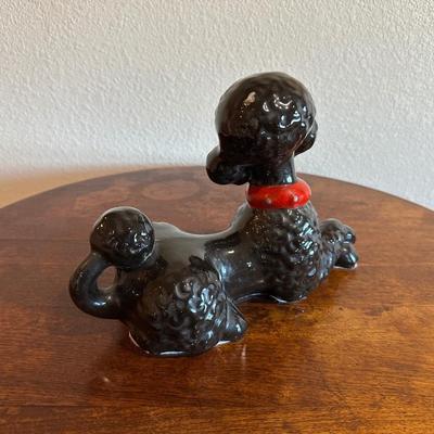 ROUND MAHOGANY SIDE TABLE W/BRASS CLAW FEET AND A CERAMIC POODLE