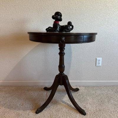 ROUND MAHOGANY SIDE TABLE W/BRASS CLAW FEET AND A CERAMIC POODLE