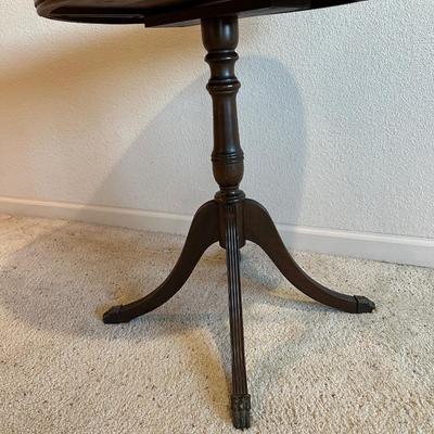ROUND MAHOGANY SIDE TABLE W/BRASS CLAW FEET AND A CERAMIC POODLE