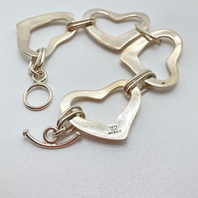 LOT 121: Sterling Interlocking Heart Toggle Bracelet - TW 30.7g 7.5"
