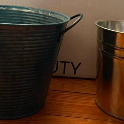 Wooden hanging basket, a small black planter with honeycomb design, 2 small metal planters and one taller decorative planter