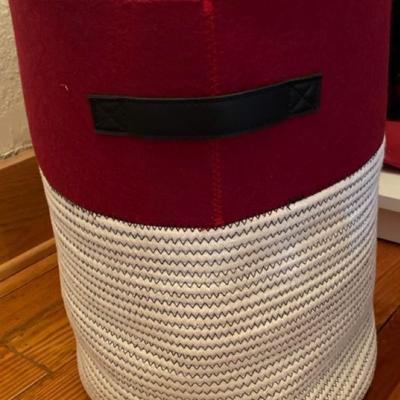 Bring some softness into your bedroom with a super soft husband, a cloth red and white clothes basket and a elegant table