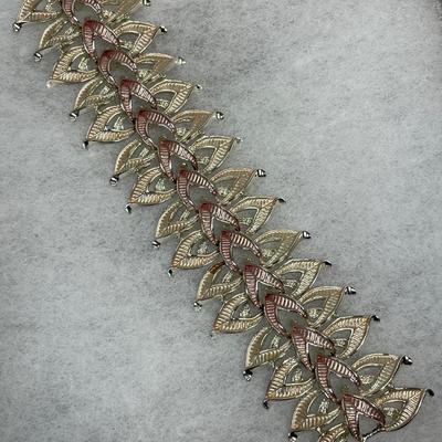 Signed wide gold tone and pink metal bracelet