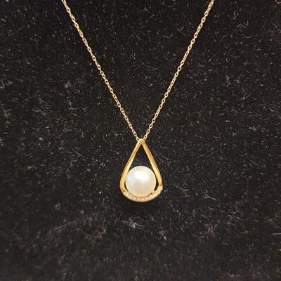 Cultured pearl pendant on gold over silver chain.