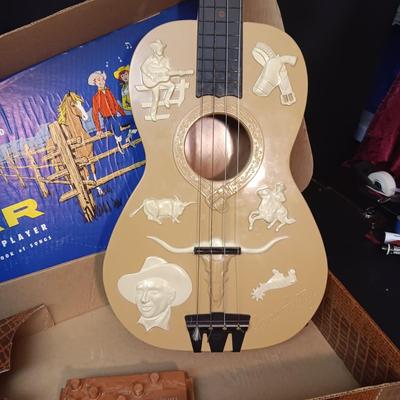 1955 CHILD'S GENE AUTRY BAKELITE GUITAR WITH RAISED DECORATION ON FACE