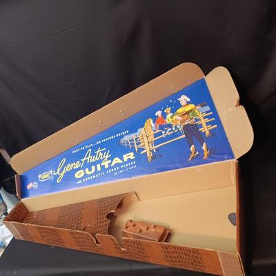 1955 CHILD'S GENE AUTRY BAKELITE GUITAR WITH RAISED DECORATION ON FACE