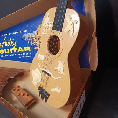 1955 CHILD'S GENE AUTRY BAKELITE GUITAR WITH RAISED DECORATION ON FACE
