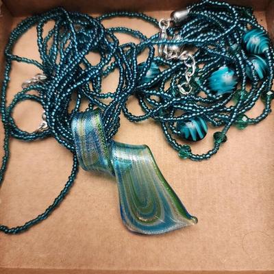 Long beaded necklace with pendant and matching earrings.