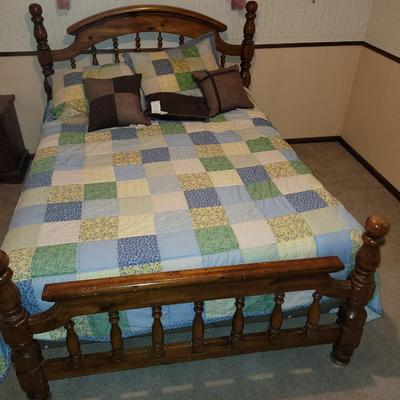 Mid century wooden queen sized bed with handmade quilt