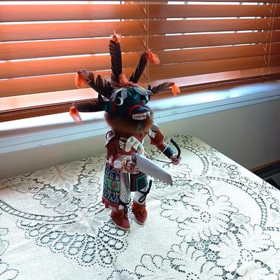 KACHINA DOLL HAND CARVED & PAINTED W/FUR & FEATHERS WIELDING A HAND SAW