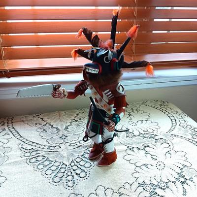 KACHINA DOLL HAND CARVED & PAINTED W/FUR & FEATHERS WIELDING A HAND SAW