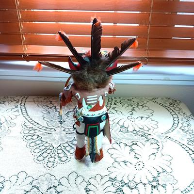 KACHINA DOLL HAND CARVED & PAINTED W/FUR & FEATHERS WIELDING A HAND SAW